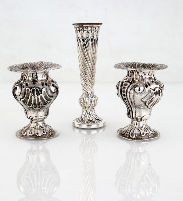 Vaso unifleur e coppia di anforette in argento sbalzato