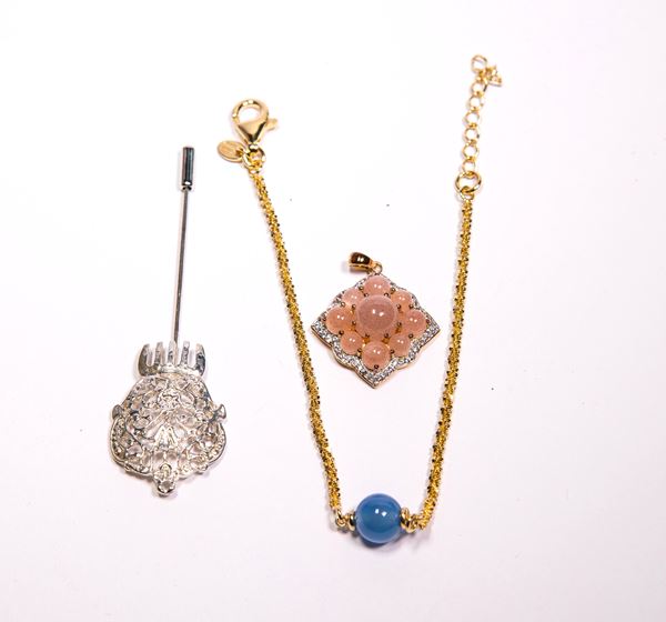 Gruppo di tre pezzi con pendente, spilla e bracciale in argento e metallo