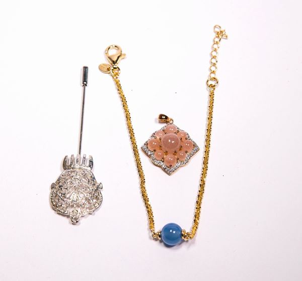 Gruppo di tre pezzi con pendente, spilla e bracciale in argento e metallo