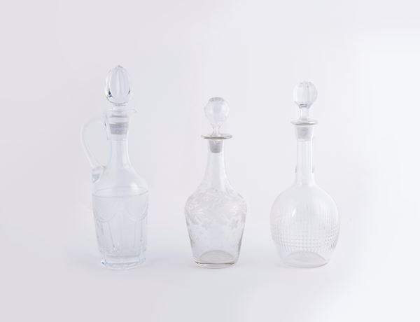 Tre bottiglie diverse con tappo ed un'oliera in vetro