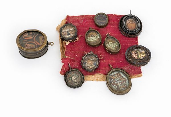 Lotto composto da nove reliquiari devozionali a capsula ed una piccola scatola