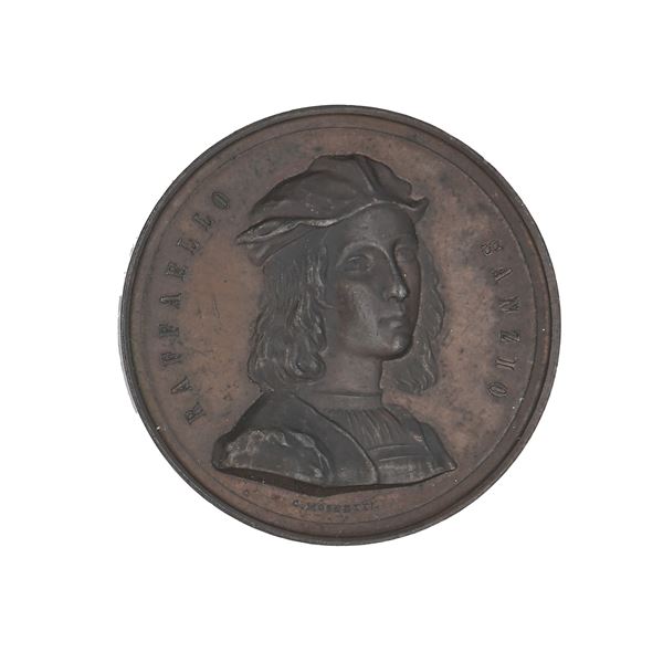 Carlo Moscetti - Medaglia in bronzo commemorativa di Raffaello Sanzio (1483-1520) per ricordare il quarto centenario della nascita; datata 1883 e firmata Moscetti D/ Busto del pittore con berretto R/ L'ASSOCIAZIONE ARTISTICA INTERNAZIONALE DI ROMA NEL IV CENTENARIO DELLA NASCITA DEL SOMMO MAESTRO XXVIII  MARZO MDCCCLXXXIII