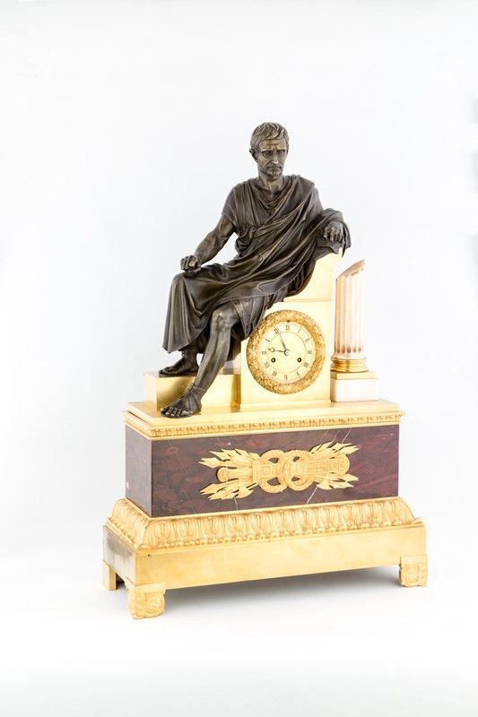 OROLOGIO IN BRONZO DORATO CON FIGURA SEDENTE ISPIRATA A BRUTO DEI MUSEI CAPITOLINI DI ROMA, FRANCIA 1815 CIRCA.