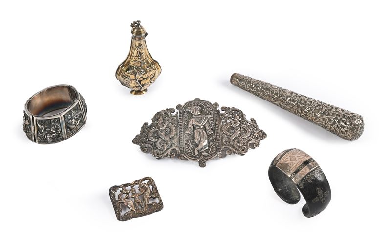 Lotto composto da due bracciali, una fibbia, una spilla, un portaprofumo e un manico in metallo a...