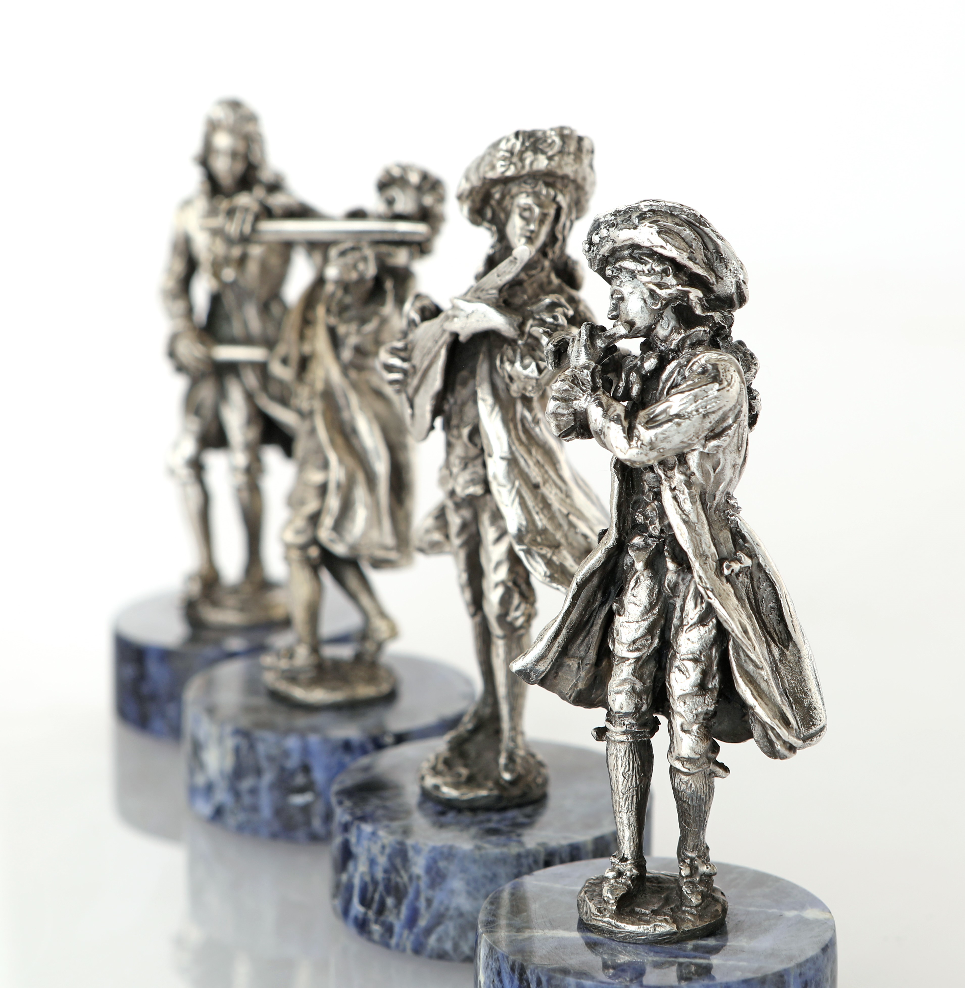 Quattro Figure Scultoree di Musici su Basi Circolari in Sodalite