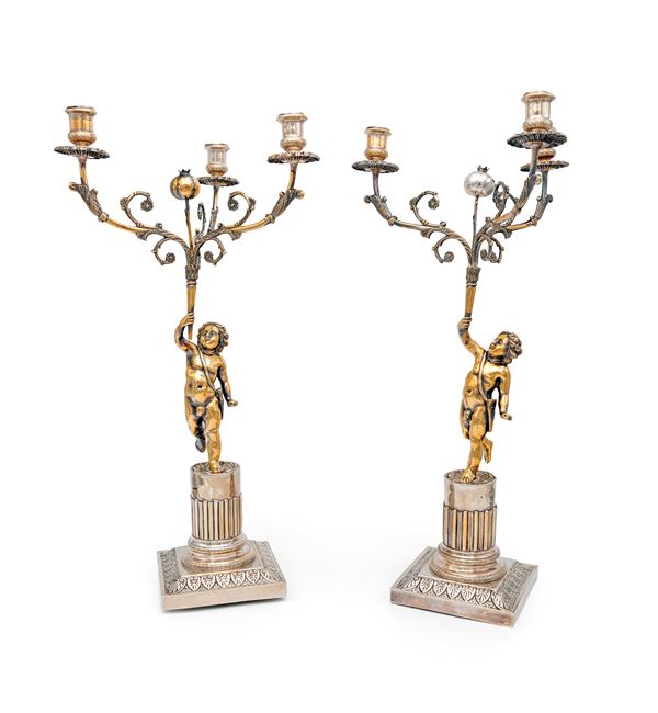 Coppia di candelabri a tre fiamme in argento e argento dorato con putti, Napoli, 1835/50