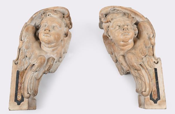 Coppia di frammenti architettonici in marmo con figure di cherubino