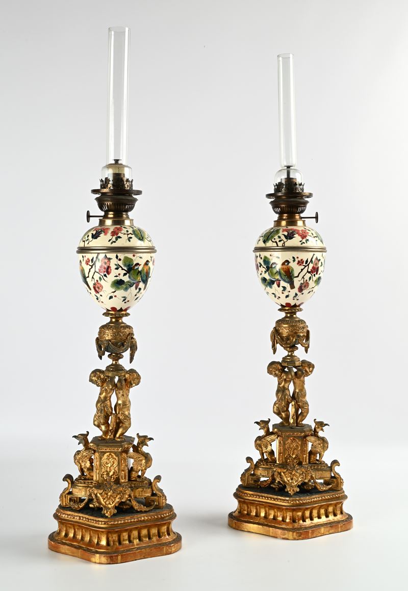 Coppia di lampade ad olio in bronzo e porcellana su base in legno dorato, XIX secolo