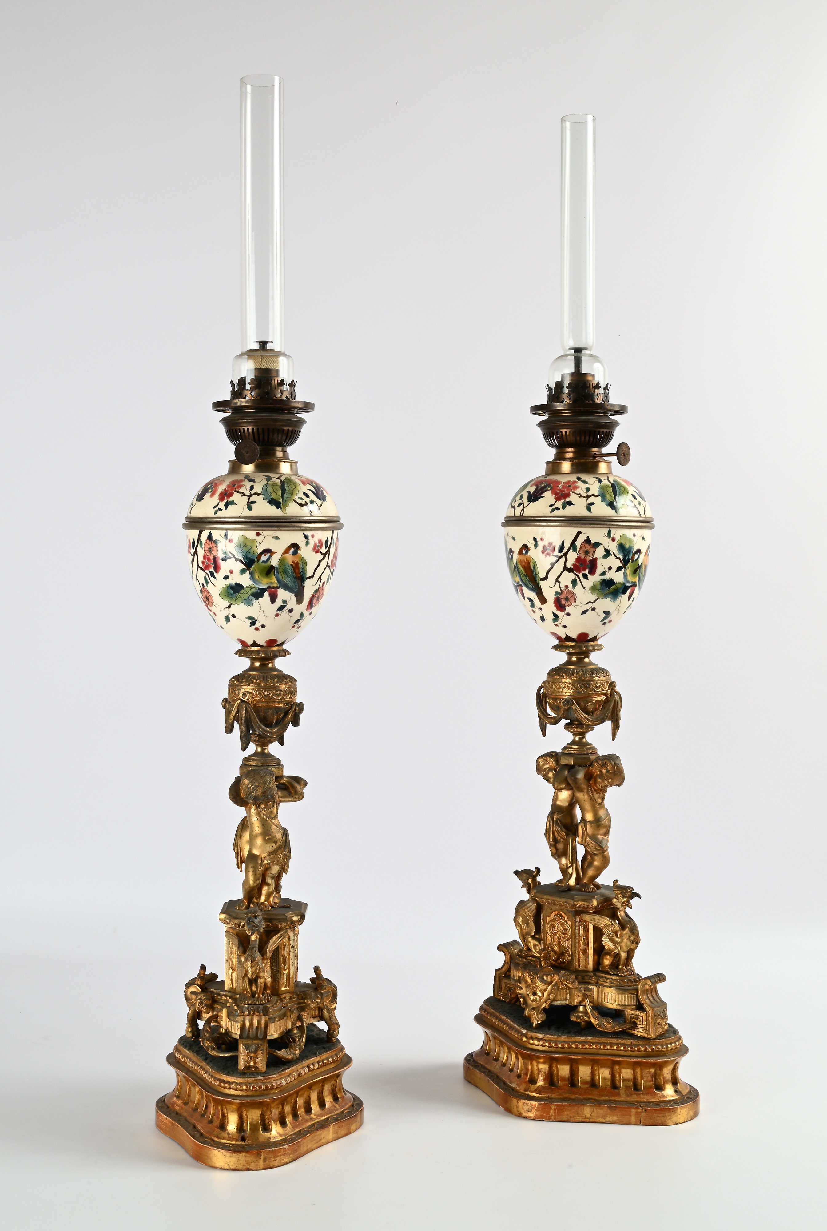 Coppia di lampade ad olio in bronzo e porcellana su base in legno dorato, XIX secolo