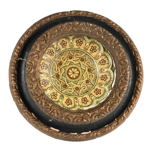 Piatto in ceramica smaltata entro cornice rotonda