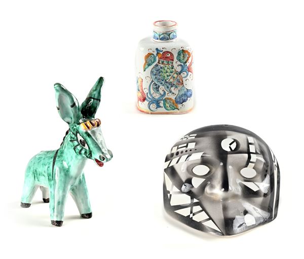Lotto di una boccetta, una maschera ed un asinello in ceramica smaltata dipinta