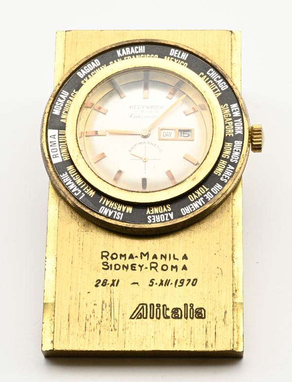 Hedy Watch Calendar - Orologio Day-Date da tavolo a carica remontoir con cassa in ottone commemorativa del viaggio papale Roma-Manila-Sidney-Roma dell'Alitalia del 28.11-05.12.1970 