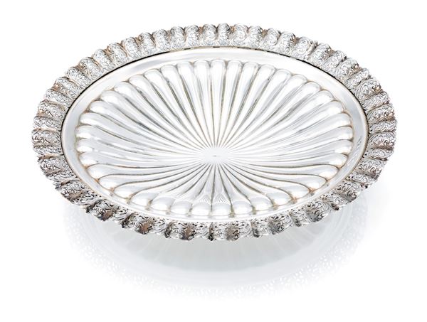 Centrotavola ovale con bordo ondulato caratterizzato da un fitto intreccio traforato a volute vegetali