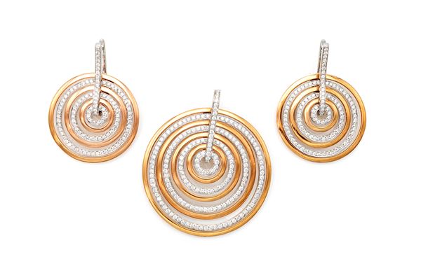 Parure di pendente e coppia di orecchini a cerchi concentrici in oro e brillanti