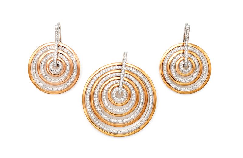 Parure di pendente e coppia di orecchini a cerchi concentrici in oro e brillanti