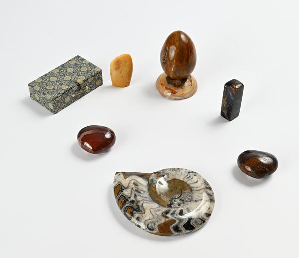 Lotto composto da 7 oggetti in pietra dura: due cuori in diaspro, un fermacarte circolare, un uovo, un sigillo squadrato, un'ammonite fossile ed una scatola in tessuto con sigillo in pietra saponaria