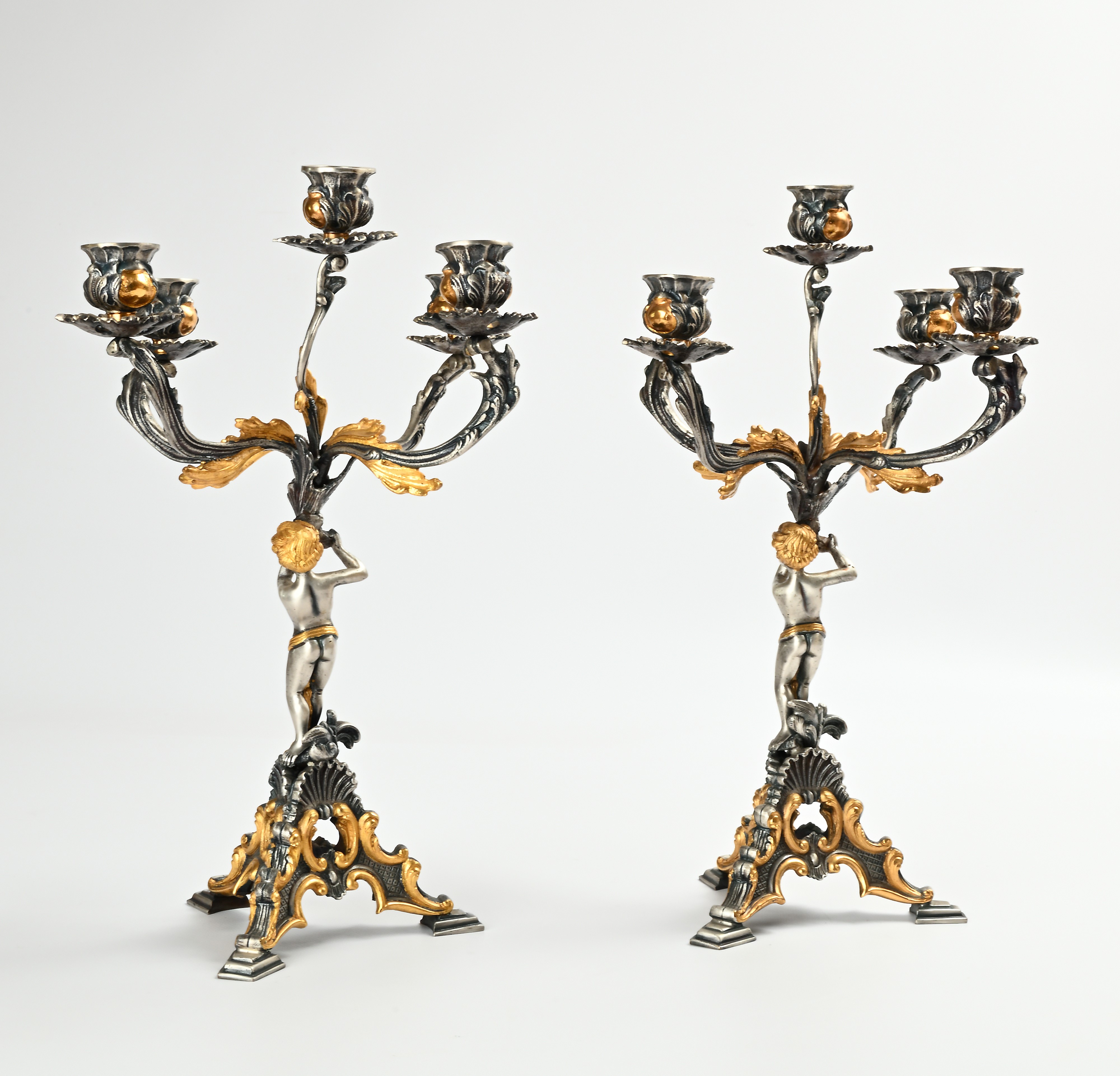 Coppia di candelabri in lega metallica a patina argentata e dorata, cinque luci con forme di amor...