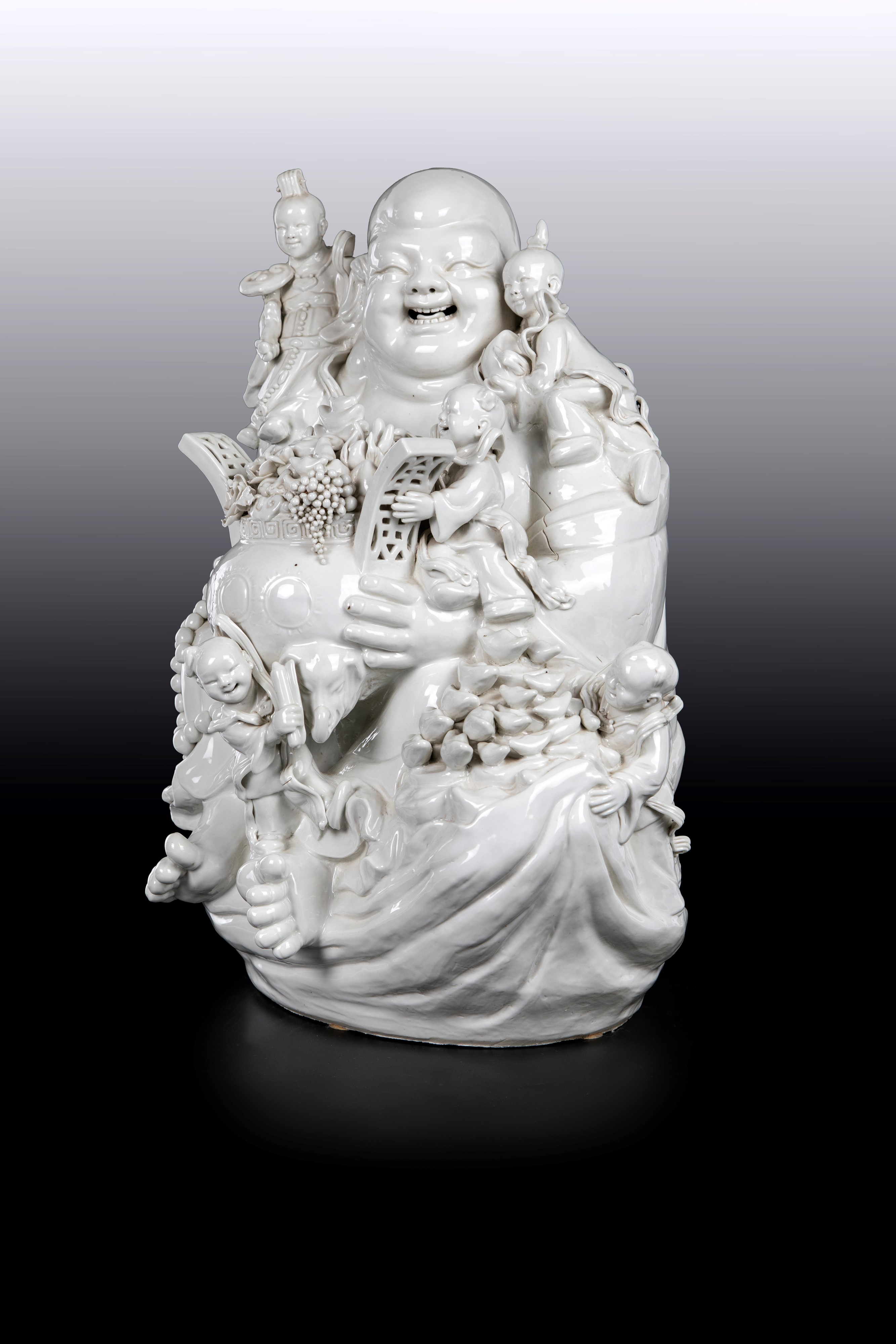Grande gruppo in porcellana blanc de Chine raffigurante Budai, Cina, dinastia Qing, XIX secolo