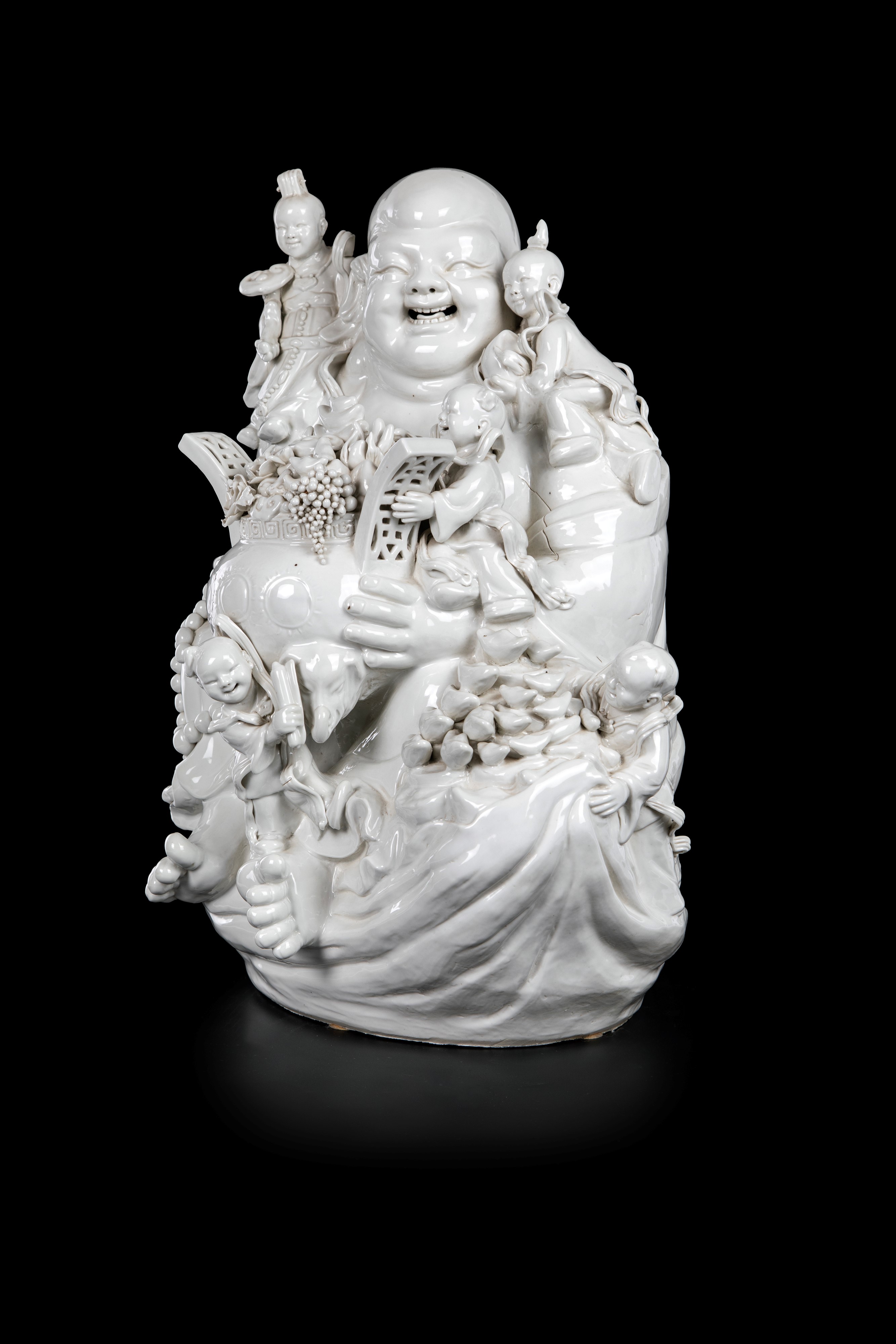 Grande gruppo in porcellana blanc de Chine raffigurante Budai, Cina, dinastia Qing, XIX secolo