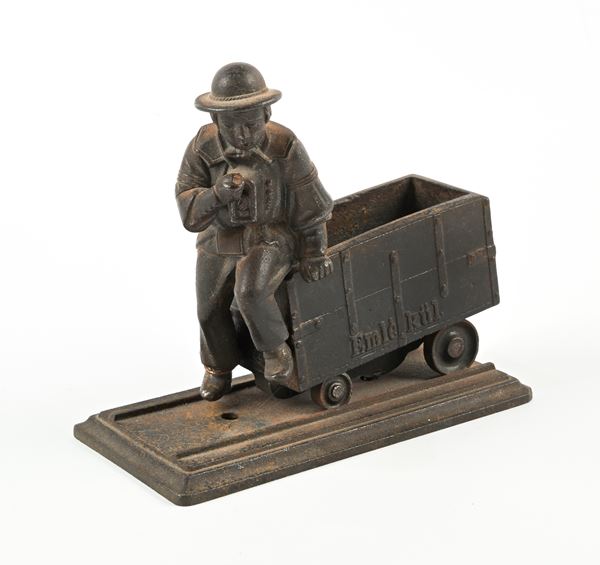 Modello scultoreo in ghisa raffigurante un minatore seduto su un carrello del carbone
