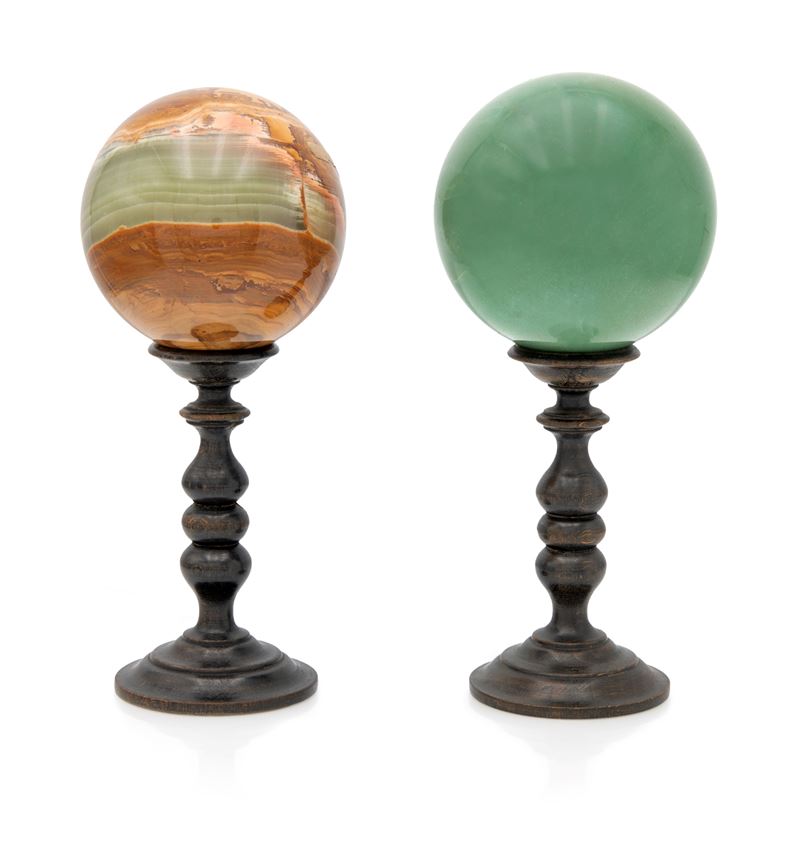 Due sfere in marmi diversi con piedistalli in legno tornito