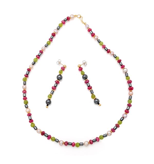 Parure di collana e orecchini in oro, rubini, peridoto, ematite e perle