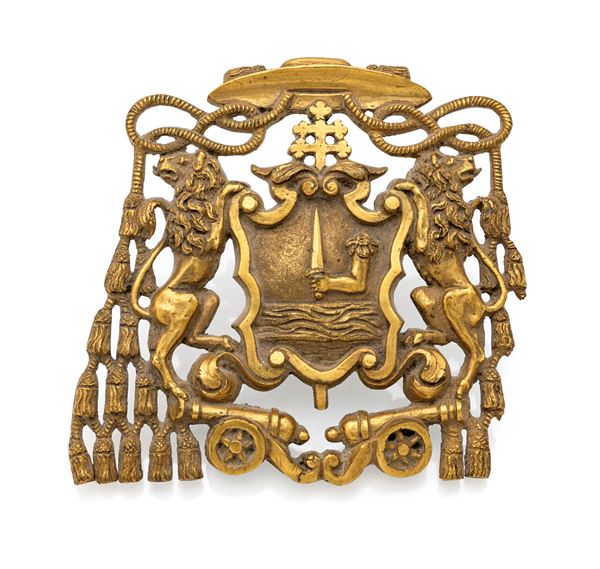 Fregio in bronzo dorato raffigurante uno stemma ecclesiastico con braccio armato di spada, XIX secolo