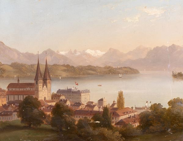 Veduta lacustre con città e montagne innevate in lontananza