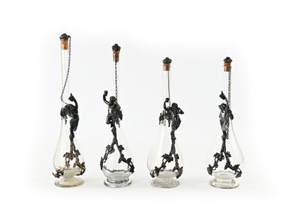 Manifattura europea, Due coppie di bottiglie in vetro incolore con manici scultorei Art Nouveau i...