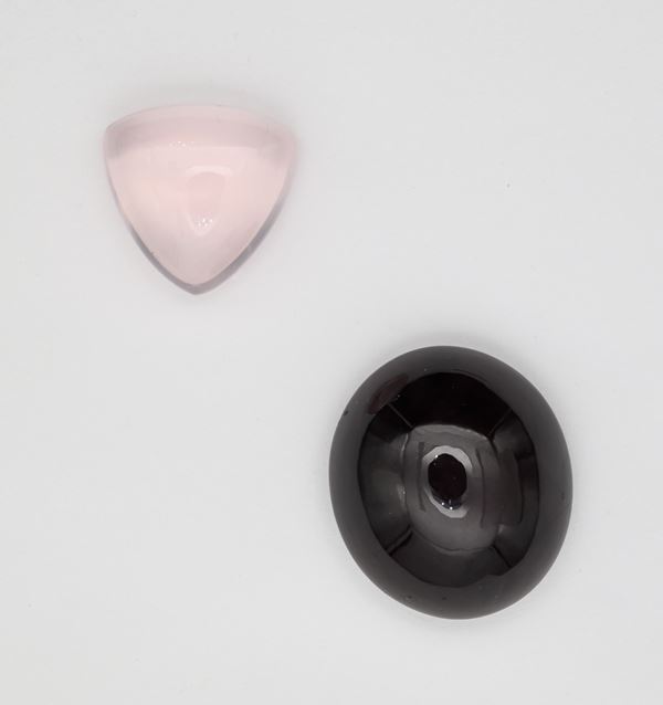 Un granato asteria in taglio cabochon di forma ovale e un quarzo rosa asteria di taglio cabochon in forma triangolo