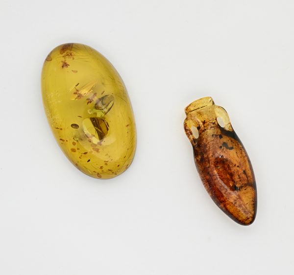 Due ambre una in taglio ovale e una incisa a vaso