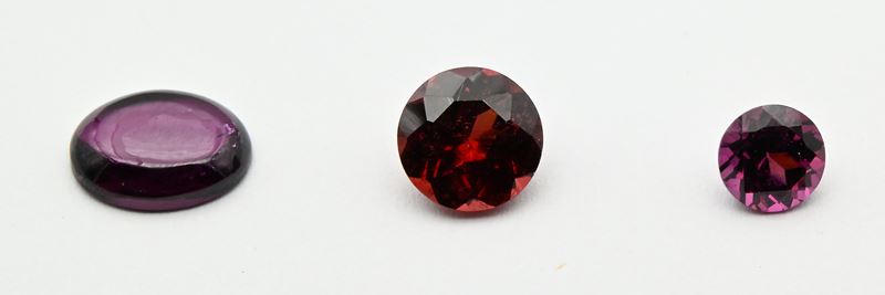 Granati, lotto di tre pietre in taglio tondo e cabochon (ct 5,20 complessivi)