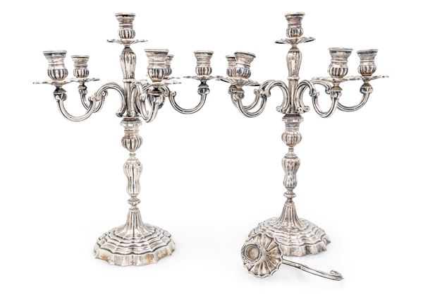 Coppia di candelabri in argento a sei luci (uno con braccio dissaldato)