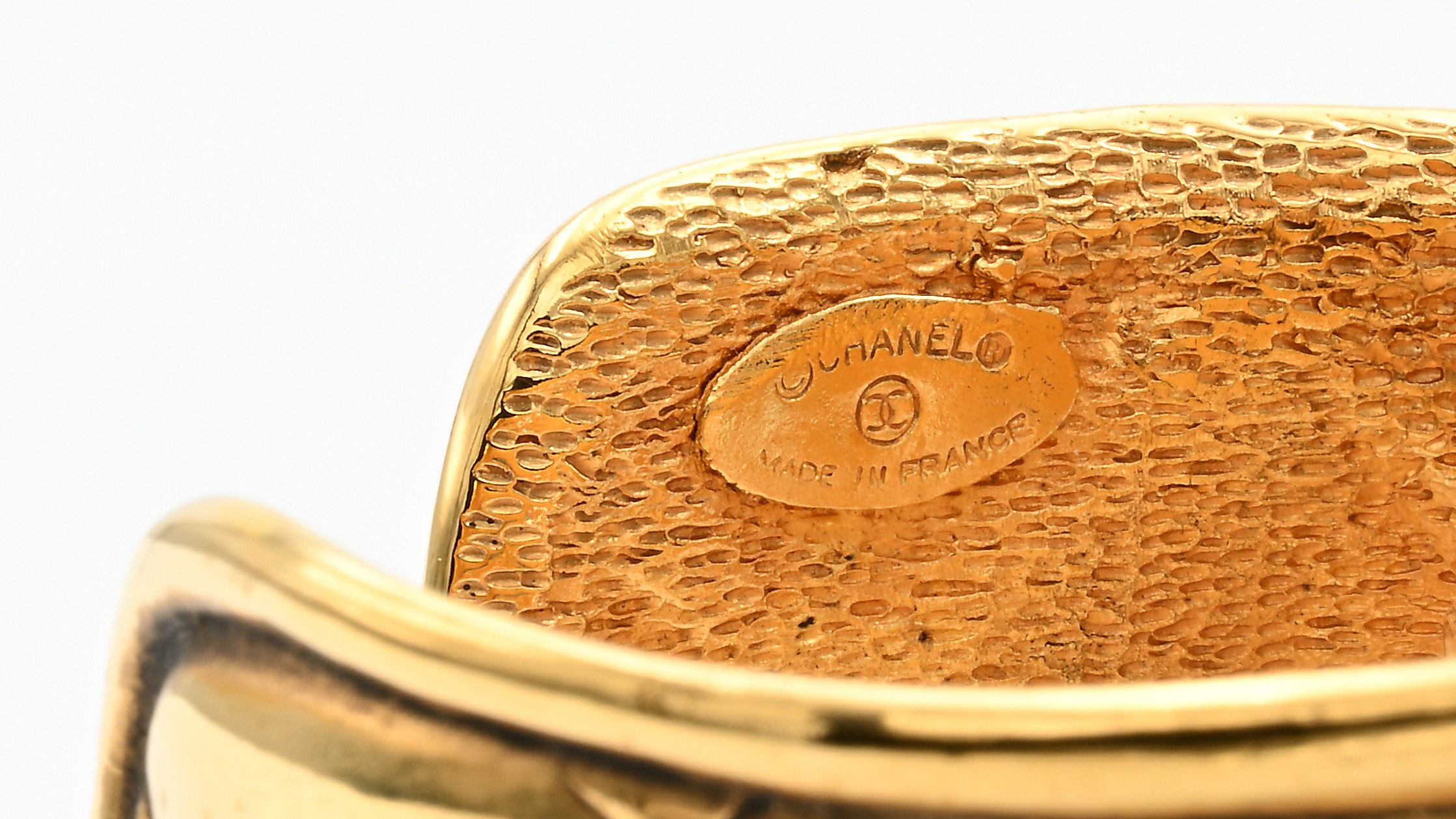 Chanel, bracciale con scritta traforata in metallo dorato