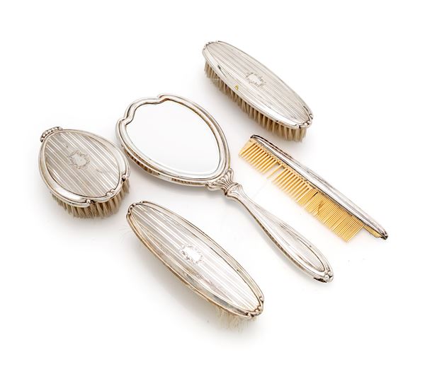 Servizio da toletta in argento composto da specchio con manico, tre spazzole diverse ed un pettine